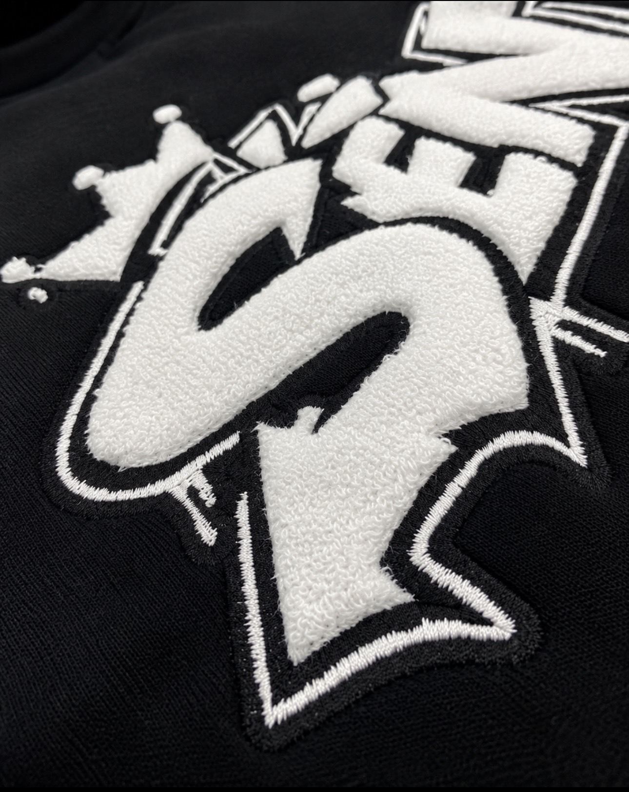 Close-up of the raised 3D chenille SÈNTRI embroidery