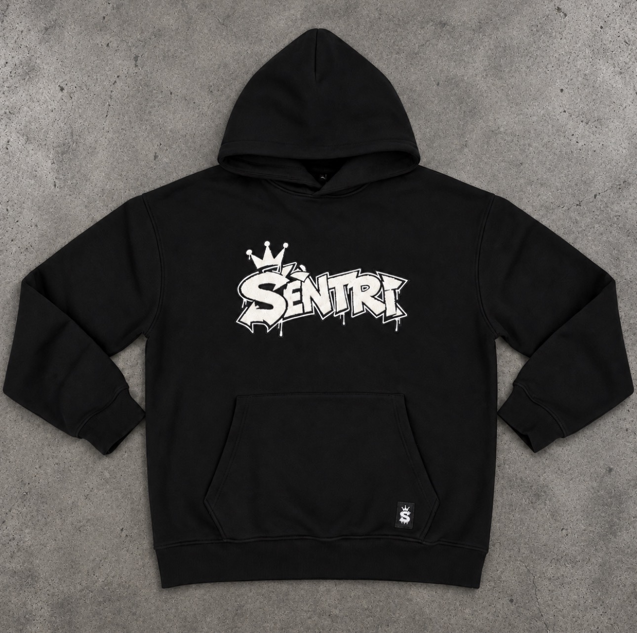 Flat lay of the SÈNTRI Drop 2 hoodie on concrete